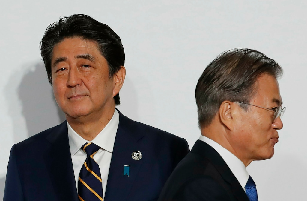 (Kim Kyung-Hoon | AP file photo) South Korean President Moon Jae-in, right, walks by Japanese Prime Minister Shinzo Abe upon his arrival for a welcome and family photo session at the G-20 leaders summit in Osaka, western Japan on June 28, 2019.