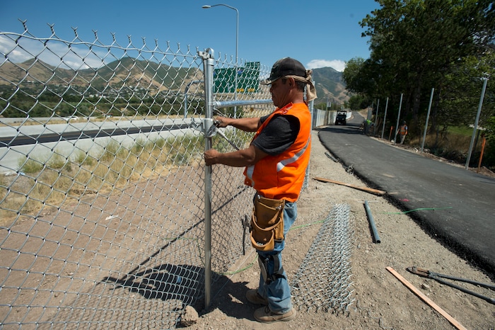 (Rick Egan | The Salt Lake Tribune) Ronie Ocha puts up a chain-link fence along a new segment of Parley's Trail, Wednesday, Aug. 30, 2017.
