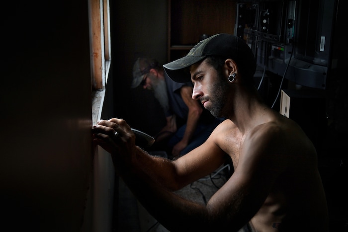 (Washington Post photo by Michael S. Williamson) Phil works with his father, Joe Manning, to replace some moldy wallboard in Phil's mobile home.