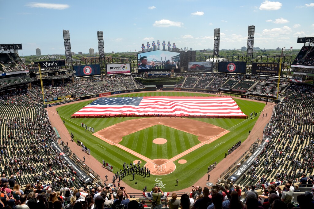 (Mark Black | AP file photo) In this July 4, 2019, file photo, an American Flag is unfurled in the outfield during the playing of the National Anthem before the start a baseball game between the Chicago White Sox and the Detroit Tigers in Chicago. Major League Baseball owners gave the go-ahead Monday, May 11, 2020, to making a proposal to the players’ union that could lead to the coronavirus-delayed season starting around the Fourth of July weekend in ballparks without fans, a plan that envisioned expanding the designated hitter to the National League for 2020.