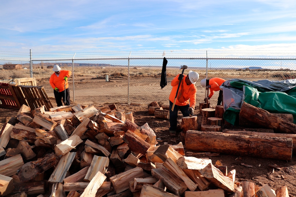 (Melissa L. Sevigny | Arizona Public Radio via AP) In this Dec. 6, 2019, photo, workers employed by the Village of Tewa chop wood delivered from the White Mountain Apache Timber Company in the Village of the Tewa administration building on the Hopi Nation, in Ariz. Navajo and Hopi families in northeastern Arizona that have long relied on coal to heat their homes are looking to other sources after last year's closure of a coal mine.