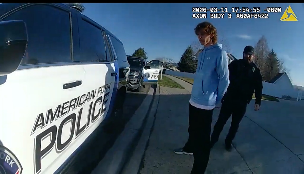 (American Fork Police Department) Police body camera shows California YouTuber Ben Schneider in handcuffs as he is escorted to an American Fork police car during his March 11, 2026, arrest.