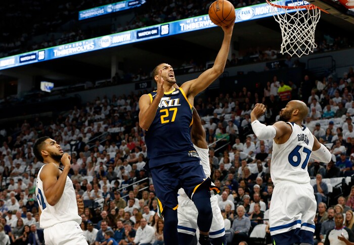 Utah Jazz's Rudy Gobert, center, of France, lays up between Minnesota Timberwolves' Karl-Anthony Towns, left, and Taj Gibson during the first half of an NBA basketball game Friday, Oct. 20, 2017, in Minneapolis. AP Photo/Jim Mone)