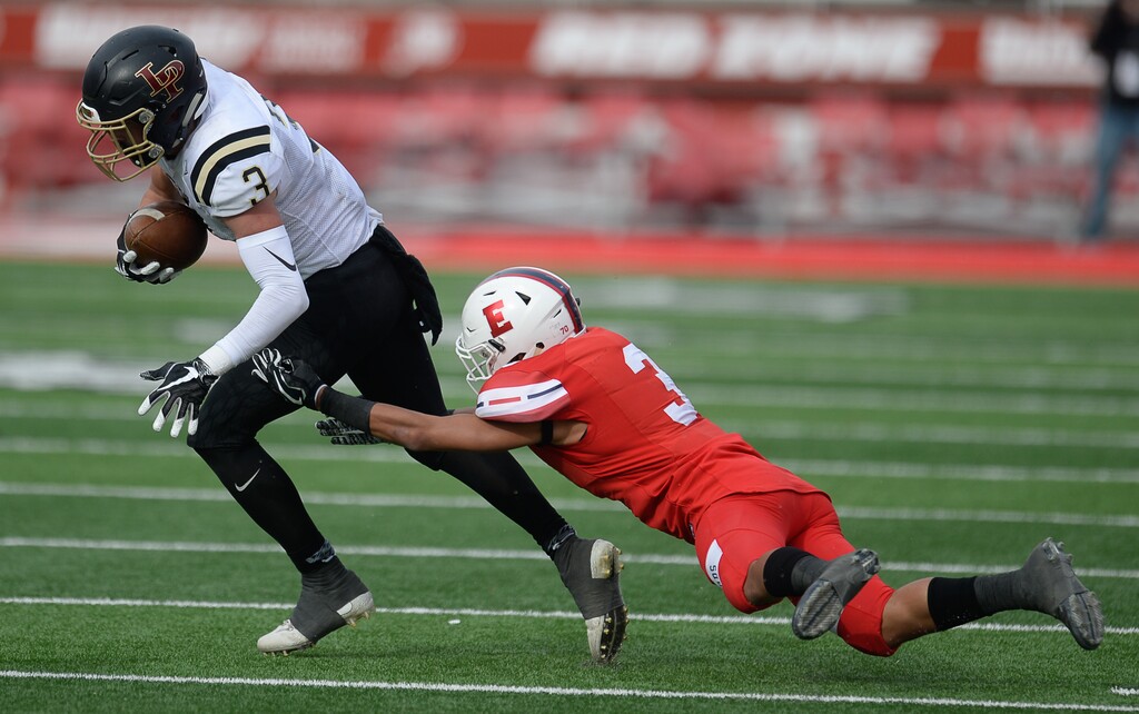 (Francisco Kjolseth  |  The Salt Lake Tribune)  Cody Collins of Lone Peak is pressured by Mekelee Gautavai of East in their class 6A semifinal game at Rice-Eccles Stadium, Friday, Nov. 10, 2017.