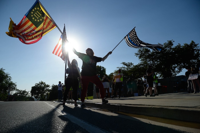 (Francisco Kjolseth  |  The Salt Lake Tribune) A couple women with the so-called Patriots Prepared wave flags as they show up in support of law enforcement as part of national day of protest against police crimes, the National Alliance Against Racist and Political Repression, the Salt Lake Civilian Police Accountability Council and other groups gather at the Utah Capitol on Saturday, July 18, 2020.
