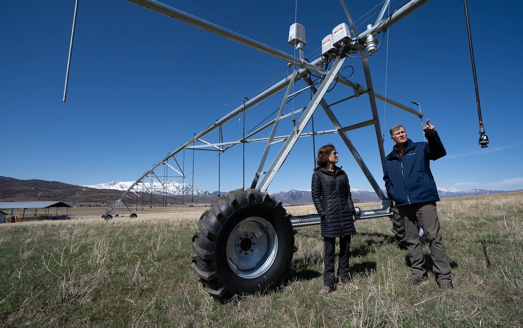 (Francisco Kjolseth | The Salt Lake Tribune) Bill White, alongside his wife, Alane, talks about the central pivot watering system he purchased to help preserve the farmland surrounding the Trappist monastery in Huntsville on Tuesday, April 13, 2021. A deal has been reached to preserve most of the 1,800-acre agricultural operation that surrounds the monastery grounds in the rapidly subdividing Ogden Valley. White has agreed to donate much of the development rights to the land so that it remains as agricultural open space. White has invested heavily in the land's agricultural operations so that it would qualify for the $8.8 million in federal grants that are funding most of the deal.