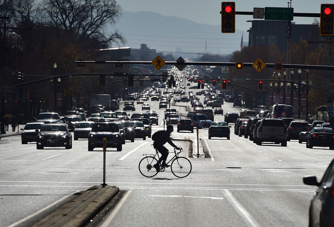 (Scott Sommerdorf   |  The Salt Lake Tribune)   A bicyclist braves downtown traffic on 300 South, while crossing State Street, Wednesday, November 22, 2017. 