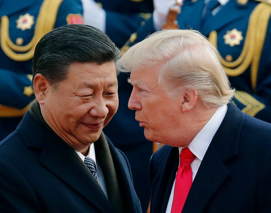 FILE - In this Nov. 9, 2017, file photo, U.S. President Donald Trump, right, chats with Chinese President Xi Jinping during a welcome ceremony at the Great Hall of the People in Beijing. Seeking China’s help on isolating North Korea through economic sanctions, Trump backed off a threat to label China a currency manipulator. He was off-and-on conciliatory on trade during an extended visit to Asia in November, and China announced it would lift restrictions on foreign investment in its banks and other financial institutions.  (AP Photo/Andy Wong, File)