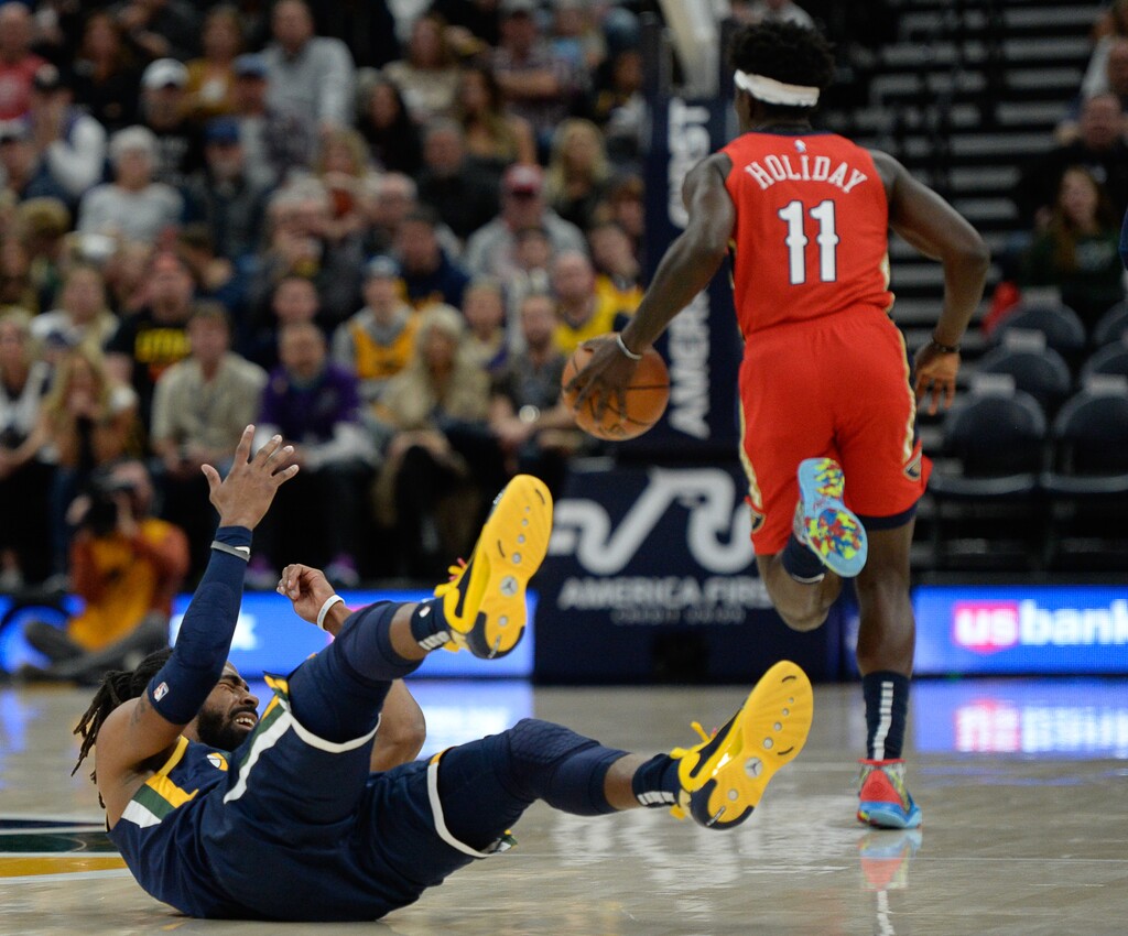 (Francisco Kjolseth | The Salt Lake Tribune) Utah Jazz guard Mike Conley (10) gets pushed over by New Orleans Pelicans guard Jrue Holiday (11) as the Utah Jazz host the New Orleans Pelicans in their NBA basketball game at Vivint Smart Home Arena in Salt Lake City on Sat. Nov. 23, 2019.