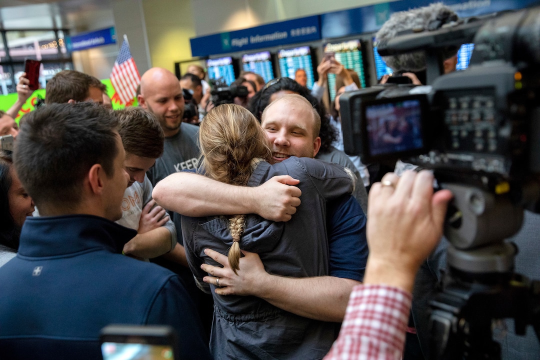Josh Holt, middle, is greeted by family and friends upon returning to Salt Lake City after receiving medical care and visiting President Donald Trump in Washington on Monday, May 28, 2018. Holt was freed this weekend after being held in a Venezuelan jail for nearly two years. (AP Photo/Kim Raff)
