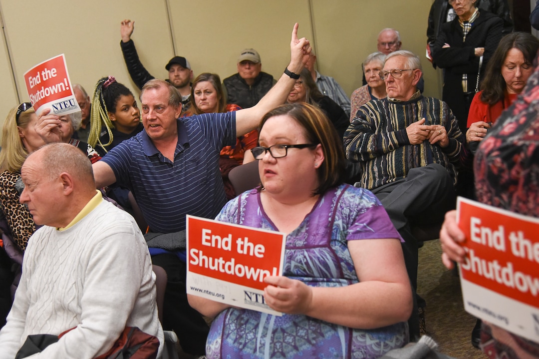 (Francisco Kjolseth  |  The Salt Lake Tribune)  Gordon McKinney, left, a federal worker with the IRS in Ogden shouts out his claim that a colleague with diabetes died last week because of the shutdown and was unable to buy her medications as U.S. Senator Mitt Romney visits some of the overflow rooms after holding a town hall meeting at the Davis County administration building, Tuesday, January 22, 2019, to hear from local residents.