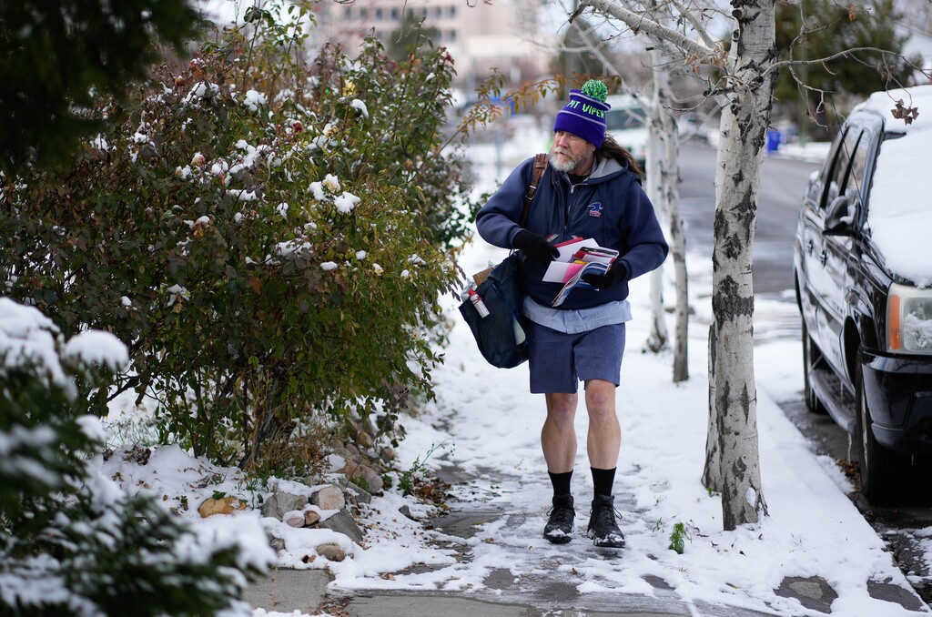 (Francisco Kjolseth | The Salt Lake Tribune) Mail carrier Aaron Saxon, who has been an employee of the U.S. Postal Service for 26 years, delivers mail on Saturday Dec. 11, 2021 in South Salt Lake. Working his 13th day in a row, he expects to work straight through to Christmas. He works extra shifts during the holidays so his co-workers with kids can be with their families.