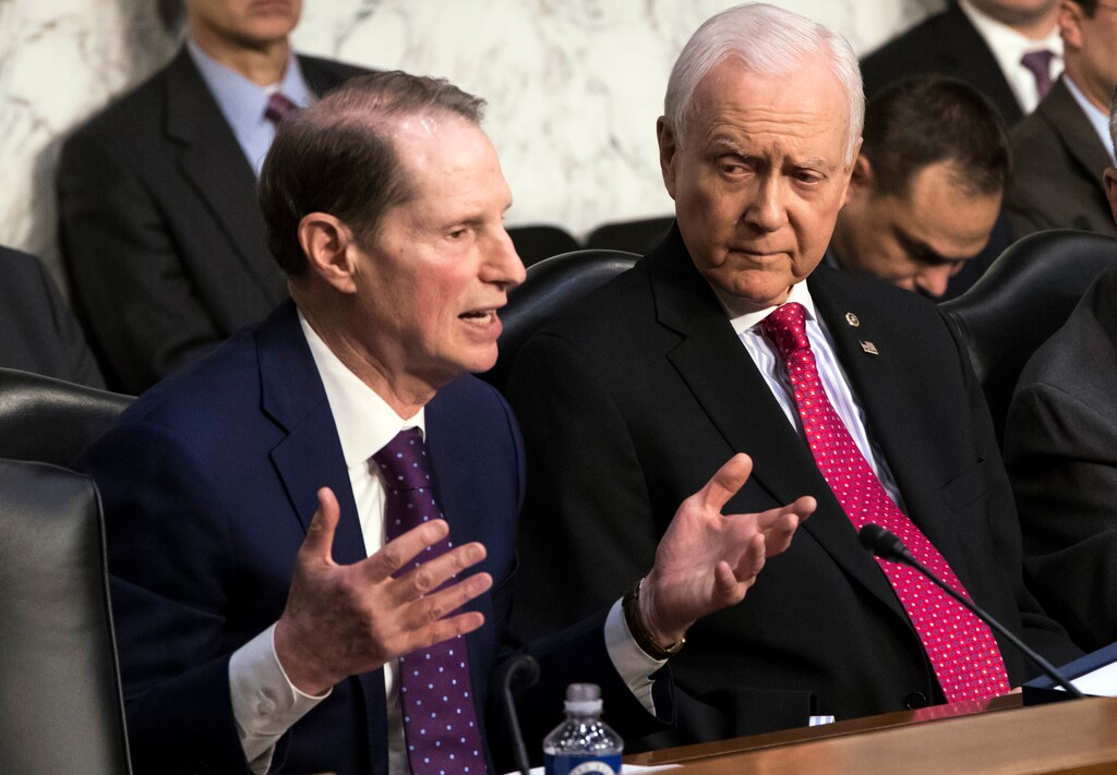 Sen. Ron Wyden, D-Ore., left, the top Democrat on the Senate Finance Committee, criticizes the Republican tax reform plan while Chairman Orrin Hatch, R-Utah, listens to his opening statement as the panel begins work overhauling the nation's tax code, on Capitol Hill in Washington, Monday, Nov. 13, 2017. The legislation in the House and Senate carries high political stakes for President Donald Trump and Republican leaders in Congress, who view passage of tax cuts as critical to the GOP's success at the polls next year. (AP Photo/J. Scott Applewhite)