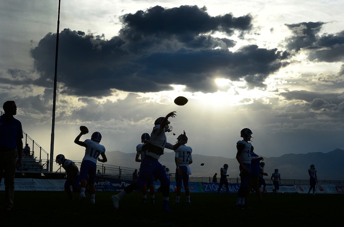 (Scott Sommerdorf  |  The Salt Lake Tribune)  Bingham player practice under the threatening weather as Brighton hosted rival Bingham in a 5A game played Friday, September 26, 2014. The game was halted for thirty minutes in the first half due to lightning in the area.