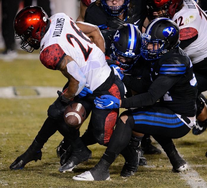 (Trent Nelson | The Salt Lake Tribune) San Diego State Aztecs running back Kaegun Williams (26) is stripped of the ball by Brigham Young Cougars linebacker Kavika Fonua (34) as BYU hosts San Diego State, NCAA football in Provo on Saturday, December 12, 2020.