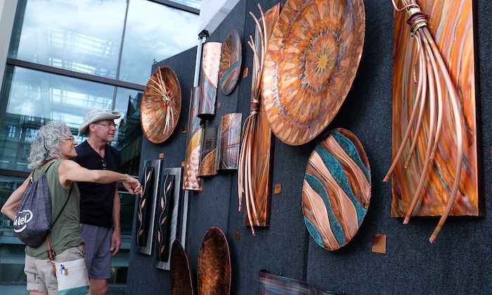 (Francisco Kjolseth  |  The Salt Lake Tribune)  Patti and Chad Spackman of Chester Springs Pa. admire the copper works by Greg Gowen of Studio G7 during the annual 2019 Utah Arts Festival as it kicks off at Library Square and Washington Square in downtown Salt Lake City, Thursday, June 20, 2019, with visual and performance art of all varieties and food for all ages from June 20-23.
