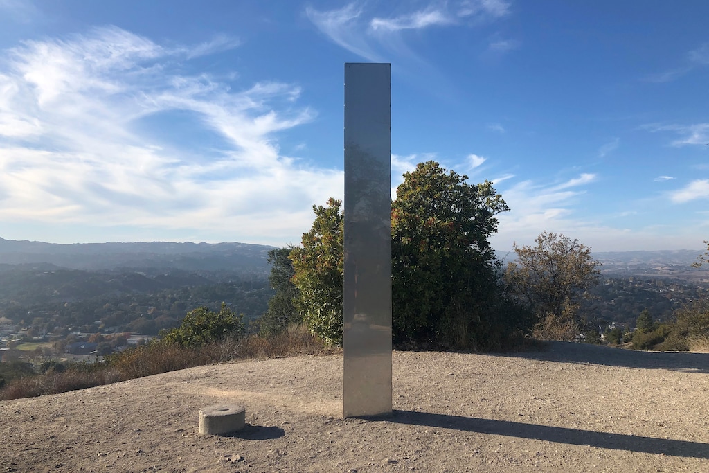 (Kaytlyn Leslie | The Tribune (of San Luis Obispo) via AP) A monolith stands on a Stadium Park hillside in Atascadero, Calif., Tuesday, Dec. 2, 2020. Days after the discovery and swift disappearance of two shining metal monoliths half a world apart, another towering structure has popped up, this time at the pinnacle of a trail in Southern California. Its straight sides and height are similar to one discovered in the Utah desert and another found in Romania. A group of men tore the structure down Thursday.