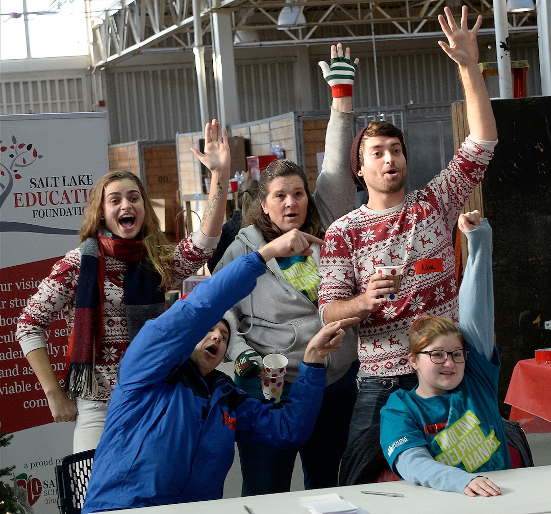 (Al Hartmann  |  The Salt Lake Tribune) 	Angel Tree volunteers wave that they are ready to fill a Christmas present order for a family in need at the Salvation Army's Angel Tree distribution warehouse at the Utah State Fairgrounds.   Needy families living in the Salt Lake School District picked up their bags of presents Friday Dec. 22, just in time for Christmas. 