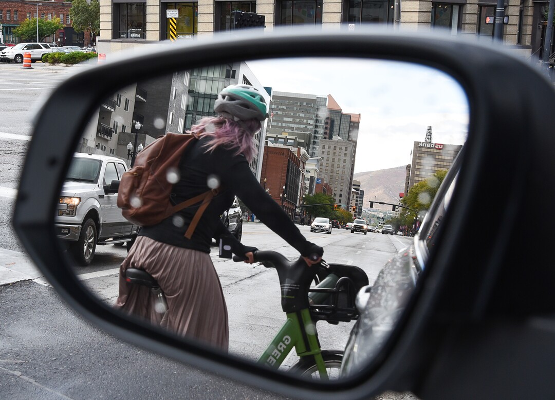 (Francisco Kjolseth  |  The Salt Lake Tribune)  A GreenBike rider moves around traffic in downtown Salt Lake City on Tuesday, Oct. 2, 2108. GreenBike was on track to have their best year yet but then Lime and Bird scooters derailed their momentum.