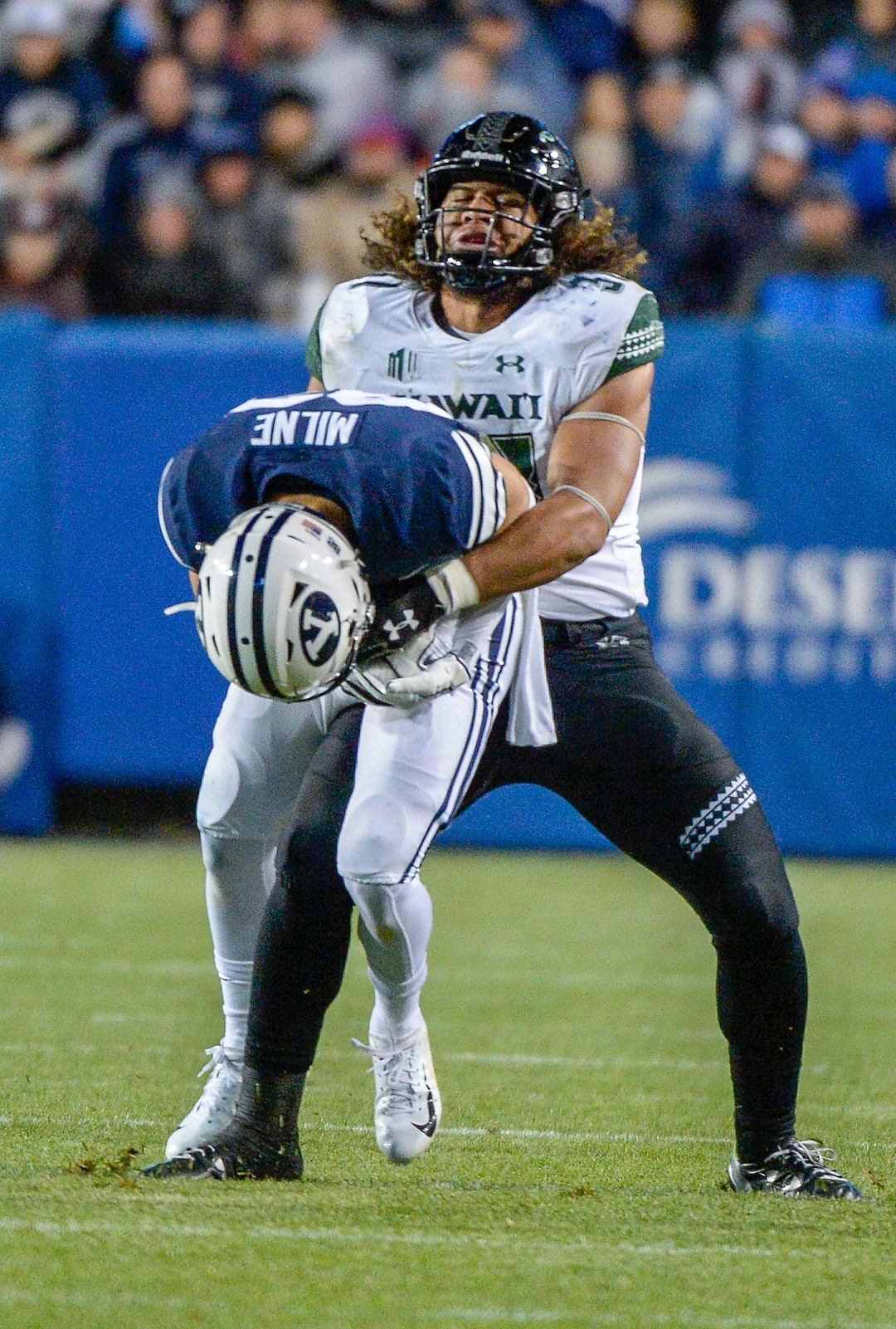 Leah Hogsten  |  The Salt Lake Tribune Hawaii linebacker Jahlani Tavai (31) picks up Brigham Young Cougars wide receiver Dax Milne (82) and slams him to the ground as Brigham Young University hosts Hawaii at Lavell Edwards Stadium in Provo, Saturday Oct. 13, 2018. BYU defeated Hawaii 49-23.