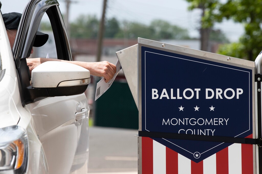 (Matt Rourke | AP) A voter drops off their mail-in ballot prior to the primary election, in Willow Grove, Pa., Wednesday, May 27, 2020.