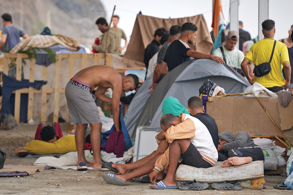 Migrants stand near their tents at El Trampolín beach in the Spanish exclave of Ceuta, Wednesday, Sept. 2, 2026. (AP Photo/Francis González)