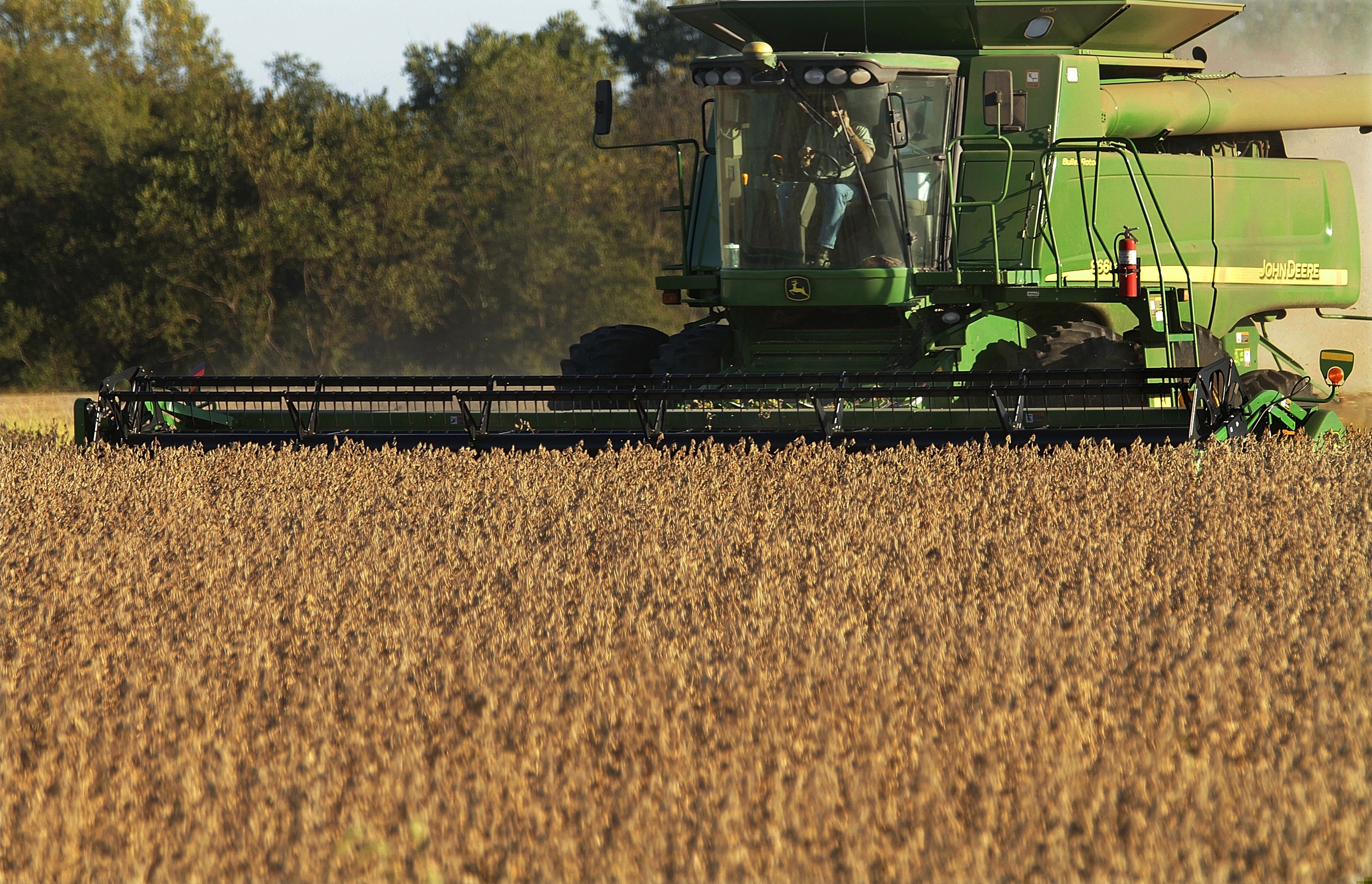 (Seth Perlman | AP file photo) Central Illinois farmers harvest soybeans in Pleasant Plains, Ill., in 2010.