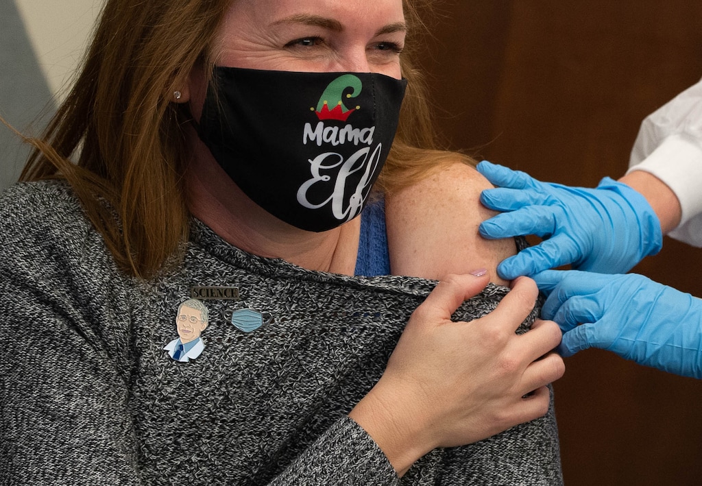 (Francisco Kjolseth  | The Salt Lake Tribune) Penelope Stoddard, clinical director at assisted living center The Ridge Foothill in Salt Lake City gets ready to receive the Moderna COVID-19 vaccine on Tuesday, Dec. 29, 2020, while wearing a pin of Dr. Anthony Fauci.