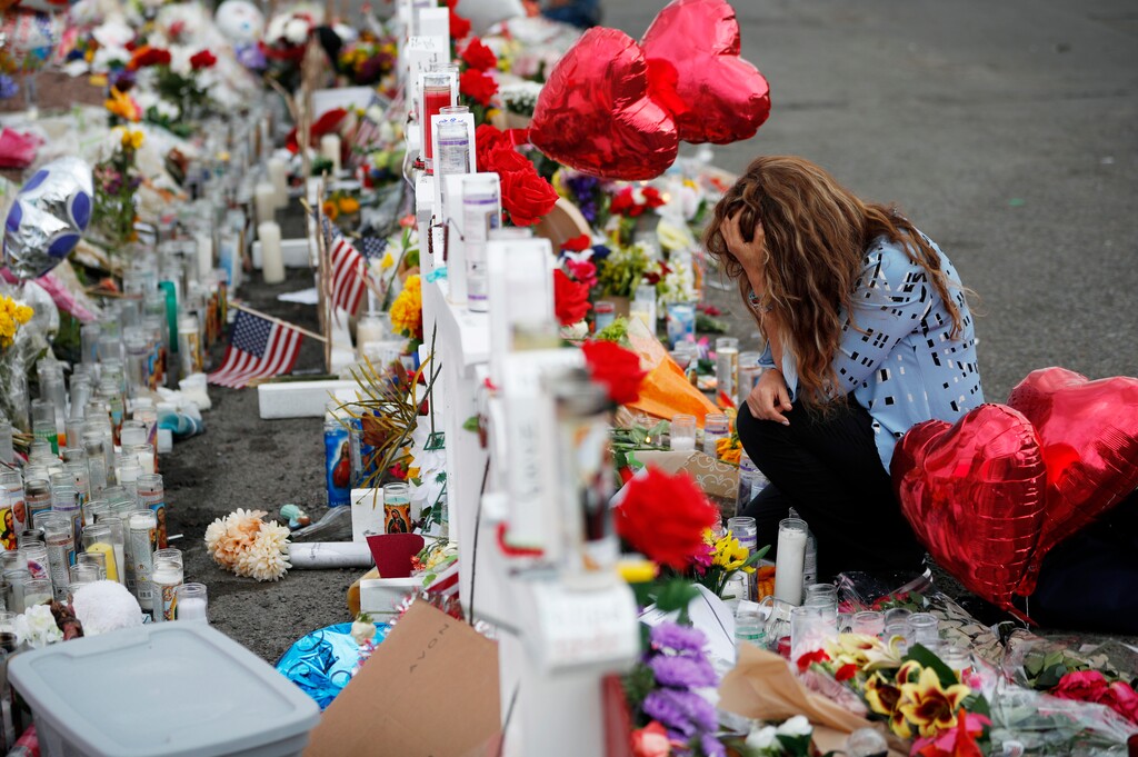 (John Locher | AP photo)
In this Aug. 6, 2019, photo, Gloria Garces kneels in front of crosses at a makeshift memorial near the scene of a mass shooting at a shopping complex in El Paso, Texas. Twenty-three people were killed and 23 others wounded on Aug. 3, 2019, at a Walmart in the border city. Authorities say the gunman targeted Mexicans because he believed they were invading the country to vote for Democrats.