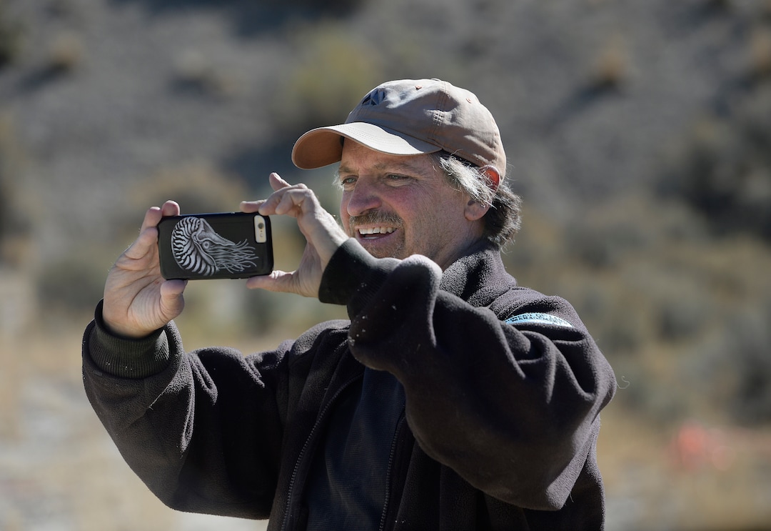 (Scott Sommerdorf   |  The Salt Lake Tribune)   Paleontologist Alan Titus makes a photo of one of the bundles of a fossilized Tyrannosaurus Rex skeleton as it is being loaded near Tropic, Utah, Sunday, October 15, 2017. The collected pieces of the animals' skeleton were airlifted to this site from the site where the skeleton was found in 2015 by Titus.