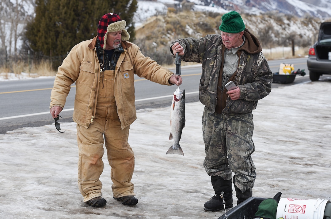 (Francisco Kjolseth  |  The Salt Lake Tribune)  Ice fisherman Scott Richardson, left, of West Jordan helps Dave Golightly of Bountiful weigh his 4lb 4oz rainbow trout he had just pulled out of Echo Reservoir in Summit County on Tuesday, Jan. 30, 2018. The reservoir next to Coalville could become a state park. 