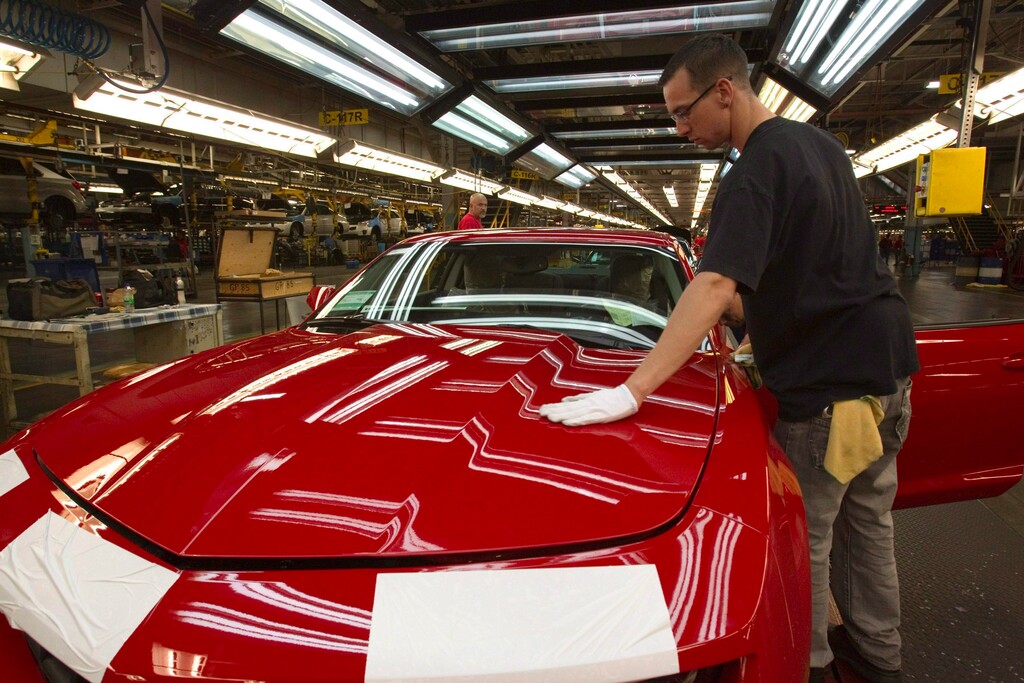 (Frank Gunn | The Canadian Press | The Associated Press) In this June 10, 2011, file photo, a worker checks the paint on a Camaro at the GM factory in Oshawa, Ontario. General Motors is closing a Canadian plant at the cost of about 2,500 jobs, but that is apparently just a piece of a much broader, company-wide restructuring that will be announced as early as Monday, Nov. 26, 2018.