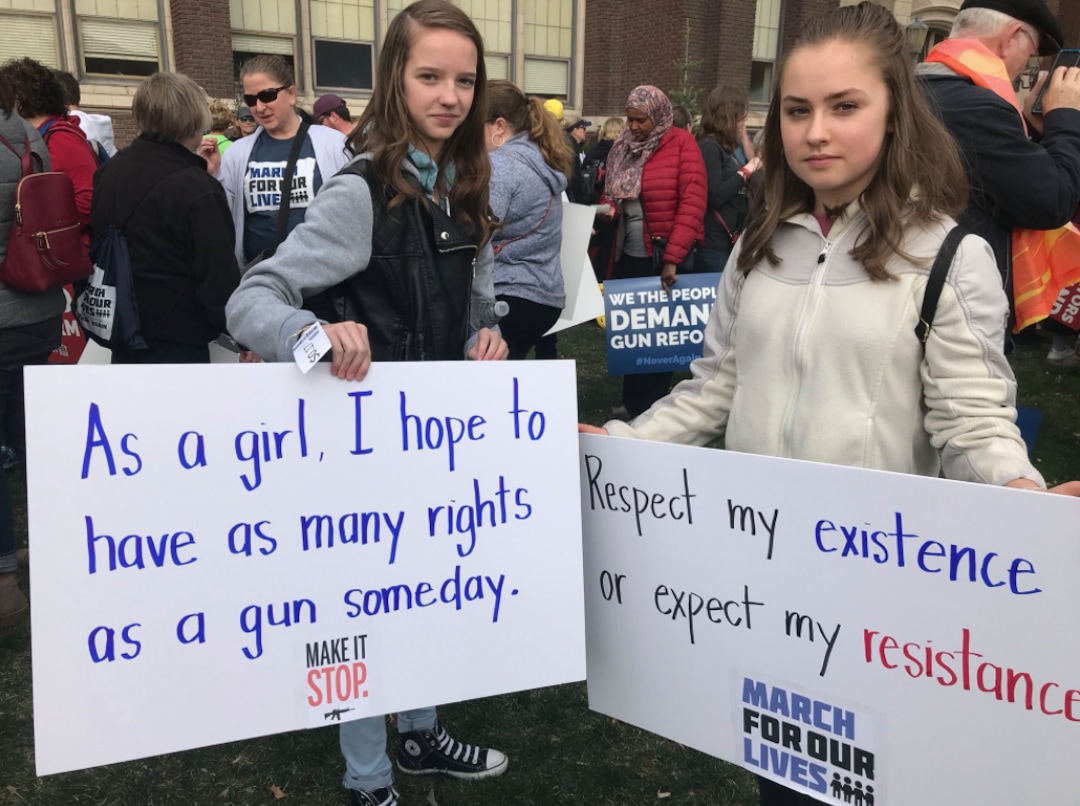 (Lillian Reed | The Salt Lake Tribune) 14-year-olds Elizabeth Young (left) and Clara Fowler (right) pose with their signs. Both said they march today because they shouldn’t have to be afraid to go to school.