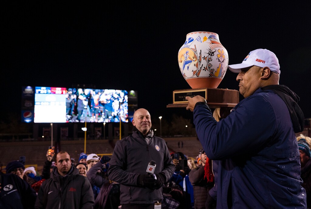 BYU head coach Kalani Sitake, right, holds the trophy during celebrations the team's victory in the New Mexico Bowl NCAA college football game against SMU in Albuquerque, N.M., Saturday, Dec. 17, 2022. (Chancey Bush/The Albuquerque Journal via AP)
