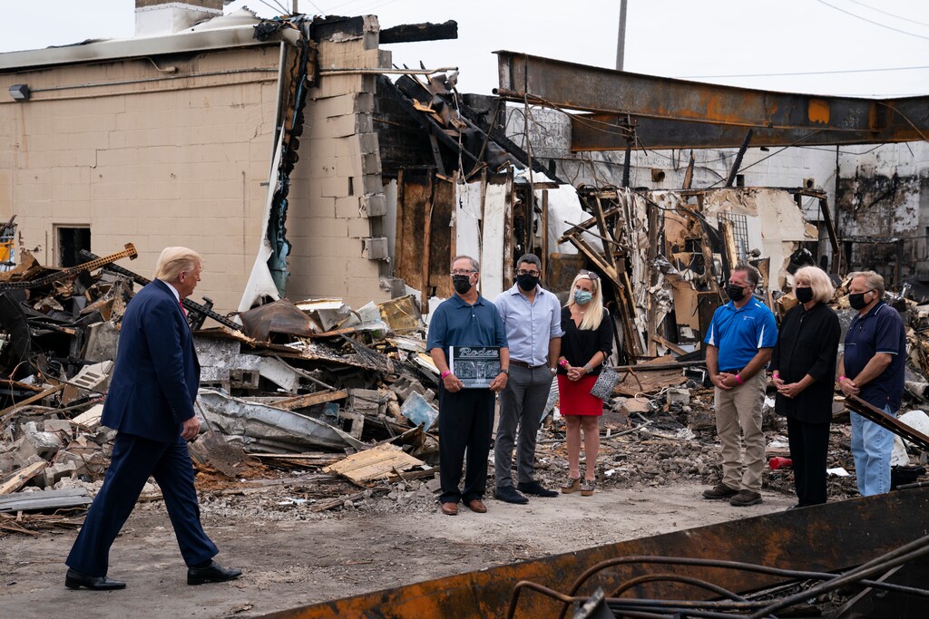 President Donald Trump speaks with business owners Tuesday, Sept. 1, 2020, as he tours an area damaged during demonstrations after a police officer shot Jacob Blake in Kenosha, Wis. (AP Photo/Evan Vucci)
