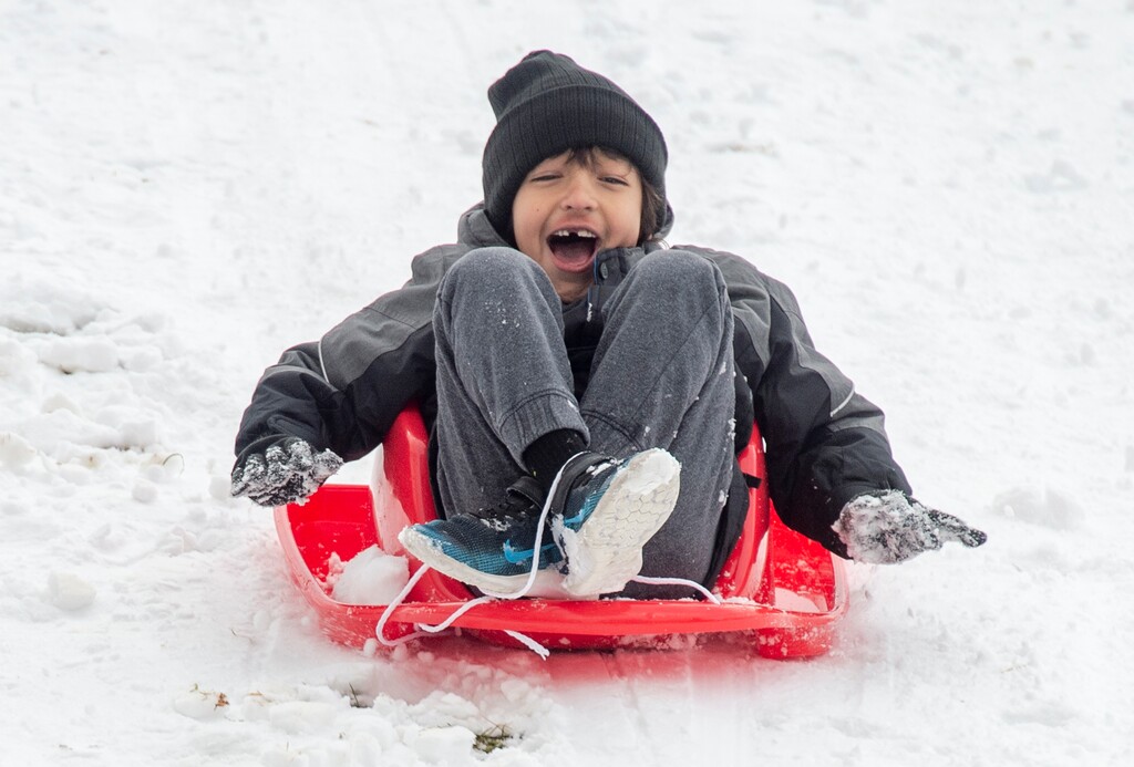 (Rick Egan  |  The Salt Lake Tribune)     Ezra Banks, 7, enjoys the new snow as he rides a sled down the hilll at Liberty Park, Wednesday, Dec. 26, 2018.