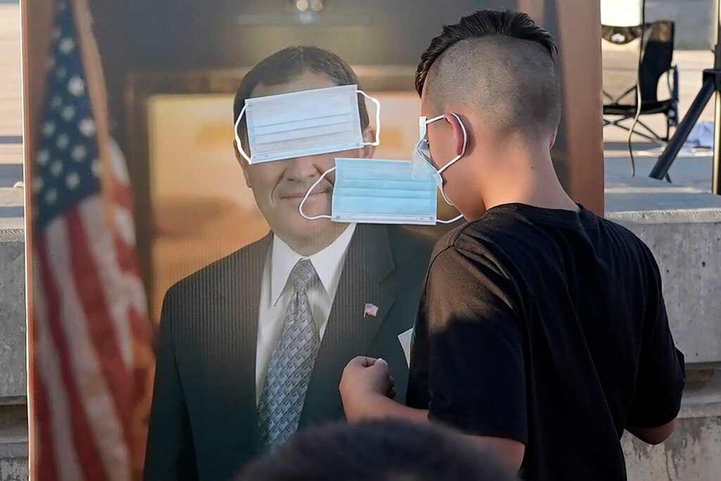 FILE - In this Saturday, Sept. 5, 2020 file photo, children play "pin the mask on Gov. Gary Herbert" during a "Trash Your Mask Protest" rally hosted by the Utah Business Revival at the Utah State Capitol in Salt Lake City. The event was held to protest Herbert's order requiring all K-12 schools in Utah to require face coverings to stop the spread of the coronavirus. According to a study by health officials in Utah and at the Centers for Disease Control and Preventionn released on Friday, Sept. 11, 2020, children in the state who caught coronavirus at day care programs or day camps spread it to about 25% of the people they encountered later, highlighting the role children can play a role in spreading the virus from child care settings to household contacts. (AP Photo/Rick Bowmer)