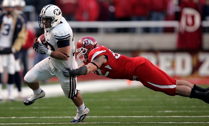 (Trent Nelson  |  Tribune File Photo)  BYU running back Bryan Kariya (33) carries the ball as Utah Utes linebacker Matt Martinez #52 dives in for a tackle at Rice-Eccles Stadium Saturday, November 27, 2010. 