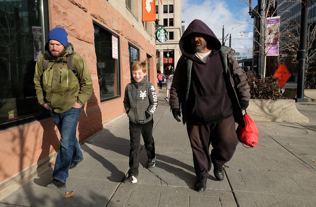 (Francisco Kjolseth  |  The Salt Lake Tribune) Ten-year-old Chase Hansen and his father John walk with Viliami Taufalele, right, after approaching him in downtown Salt Lake City and offer to buy him a meal in exchange for a little conversation on Monday, Dec. 16, 2019. Chase started an organization at the age of 6 called Project Empathy. The two of them spend time with people experiencing homelessness in an effort to connect with people on a personal level.