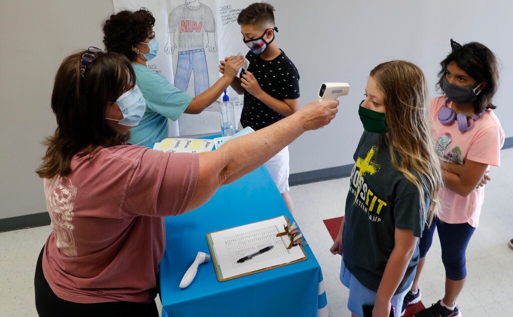 (LM Otero | AP file photo)  Amid concerns of the spread of COVID-19, science teachers a check in students before a summer STEM camp at Wylie High School in Wylie, Texas, on Tuesday, July 14, 2020.