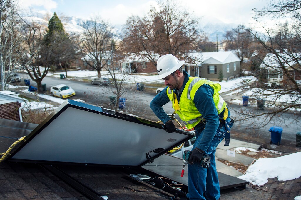 (Chris Detrick | Tribune file photo) Creative Energies lead electrician Justin Therrien installs solar panels on top of a home in Salt Lake City, seen in 2016.
Rocky Mountain Power is backing solar industry advocates’ push to reinstate Utah’s system of residential solar tax credits, but that doesn’t mean the utility and solar supporters are getting along.