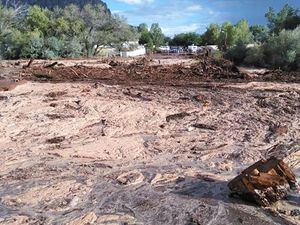 Debris and water cover the ground after a flash flood Monday, Sept. 14, 2015, in Hildale, Utah. Authorities say multiple people are dead and others missing after a flash flood ripped through the town on the Utah-Arizona border Monday night. (Mark Lamont via AP) MANDATORY CREDIT