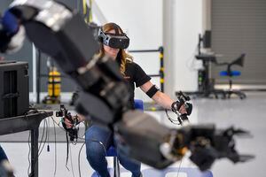 (Chris Samuels | The Salt Lake Tribune) Operator Tara Scranton tests a robot using a headset and motion controllers at Sarcos headquarters in Salt Lake City, Wednesday, April 13, 2022.