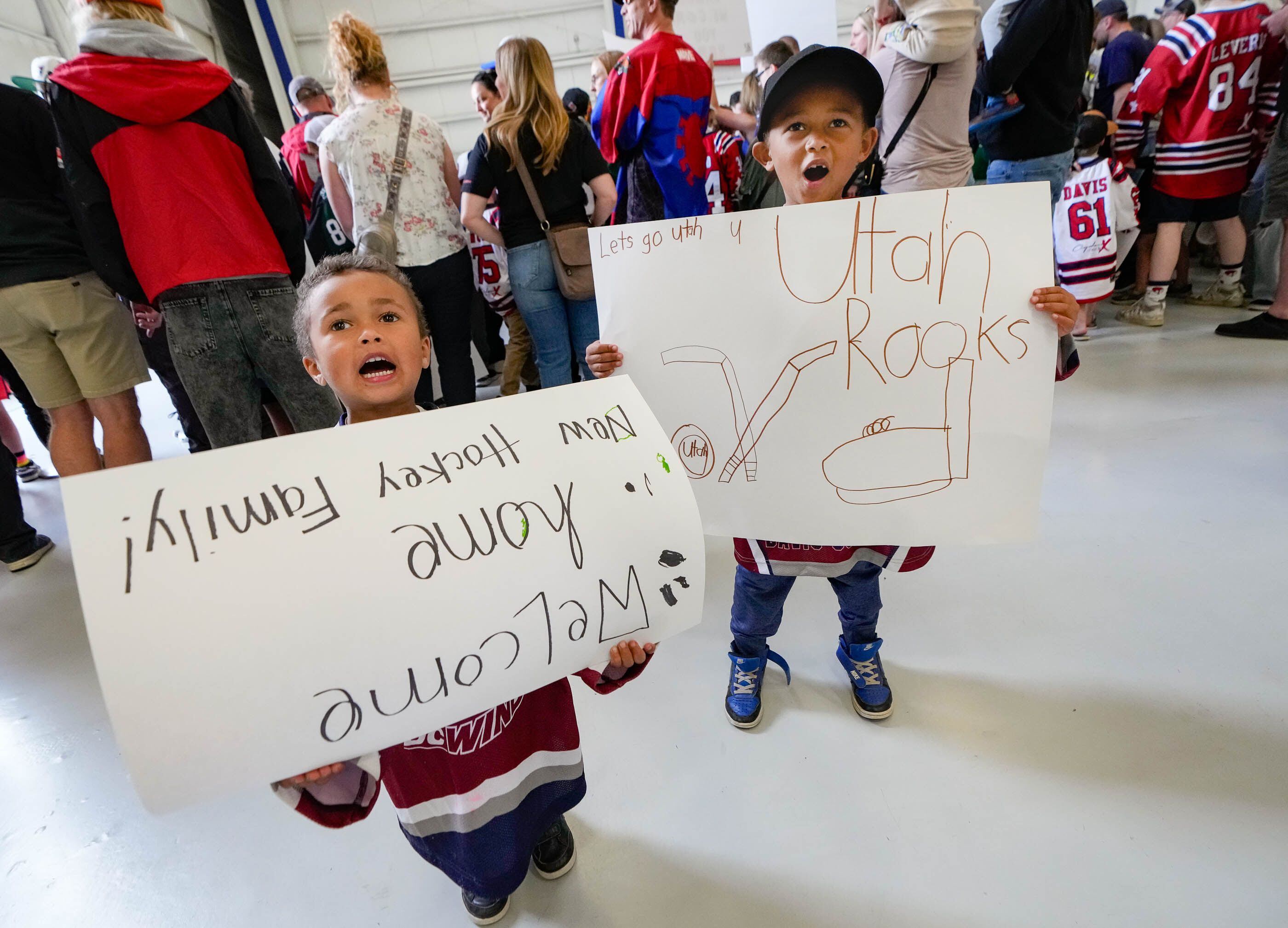 (Francisco Kjolseth  |  The Salt Lake Tribune) Young hockey fans Jordan Mortensen, 4, and his brother Nixon proudly display their posters as they wait for the arrival of the new NHL team at the airport in Salt Lake City on Wednesday, April 24, 2024.