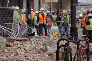 Construction workers looks at the rubble from a building after an earthquake Wednesday, March 18, 2020, in Salt Lake City.  A 5.7-magnitude earthquake has shaken the city and many of its suburbs. The quake sent panicked residents running to the streets, knocked out power to tens of thousands of homes and closed the city's airport and its light rail system.  (AP Photo/Rick Bowmer)